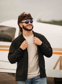 Senior posing in front of an airplane at a small hangar near Mobile Regional Airport in Mobile, Alabama.