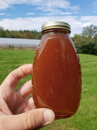 Hand holding local honey jar from Bascom Road Blueberry Farm