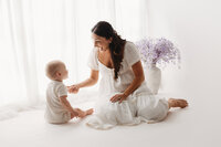Mother interacts with her 9 months old baby during Baby Milestone Portrait Session at Holy City Babies Portrait Studio in Charleston, SC.