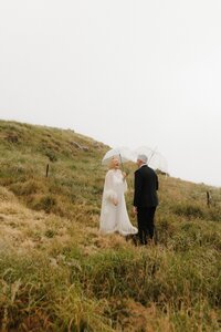 Umbrellas during an elopement in a foggy and rainy day in Christchurch