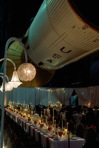 Elegant candlelit wedding reception beneath a NASA rocket at the U.S. Space & Rocket Center in Huntsville, Alabama.