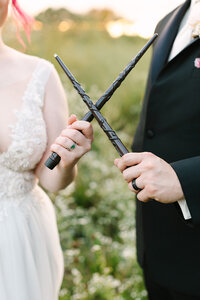 bride and groom cross harry potter wands at their Rhode Island wedding ceremony