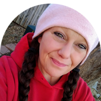 person wearing red hoodie and pink hat smiling