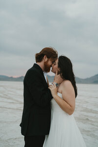 bride and groom sharing an intimate moment by the water