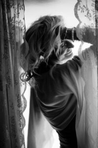 Boudoir experience in studio model behind lace curtains