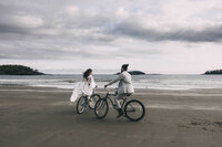 couple eloping in tofino bc at mackenzie beach resort using beach bikes