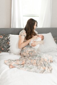 Mom and Baby girl on bed in old restored farmhouse taken by Ann Arbor Newborn Photographer