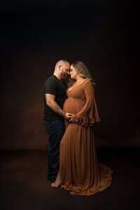 Expecting parents posed during a moment of love.