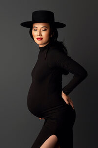 expecting mother in black dress during classic and elegant maternity photography session in North Hollywood studio