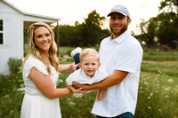 a young couple plays airplane with their toddler son during their spring family photo session in wylie,texas.