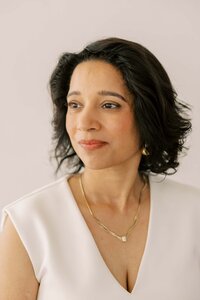 Indian woman wearing gold jewelry and soft smiling to the distance
