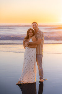 couples portrait at sunset basrefoot on beach in santa cruz