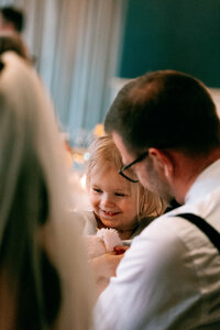 colourful candid wedding. photographer captures father and daughter laughing at the Swann inn Bibury wedding reception