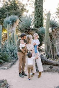 family of 5 standing and tickling each other at arizona cactus garden