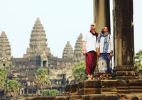 Travelers admiring the ancient temples of Angkor Wat, Cambodia, on a cultural and historical journey.