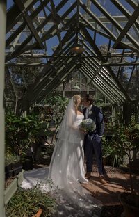 Bride and Groom kiss in greenhouse during wedding on Nantucket.