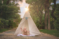 Child sitting in natural outdoor setting with soft golden backlight in New Bern NC