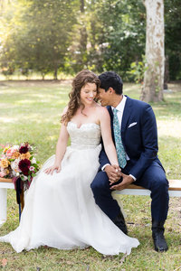A bride and groom sit together in a park in East Austin