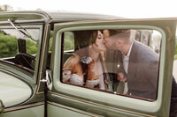 Bride and groom kissing in vintage car at Nashville Wedding