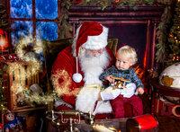 Young child holding a wooden airplane while sitting with Santa during a Santa's Magical Christmas photography session in Jacksonville, Florida with Nature's Child Photography, surrounded by vintage toys, glowing Christmas lights, and cozy holiday magic by the fireplace.