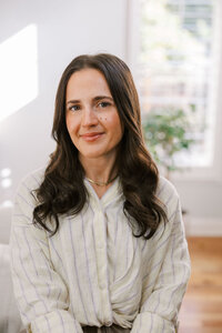 Woman sitting with on the arm of a couch for her bay area branding photography session