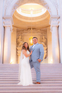 wedding couple standing on stairs at san francisco city hall wedding
