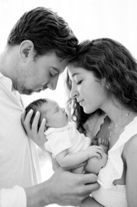 New parents holding newborn together at home Miami newborn photographer