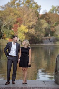 Central park engagement photos, Deborah Zoe Photography. A couple hold hands near lake in Central Park.