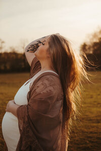 Photo of a woman during golden hour at her maternity session in bloomington indiana