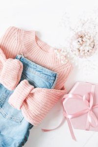 Flatlay of pink jumper, jeans and flowers