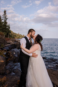Newlyweds pose on the shore of Lake Superior
