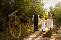 Romantic english countryside portrait of bride and groom holding young girls hands
