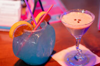 Two cocktails sitting on a bar together