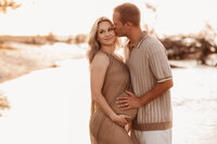 Folly Beach Maternity Photographer -- Pregnant woman poses for Maternity Photos at the Lighthouse Inlet Heritage Preserve on Folly Beach with iconic views of the Morris Island Lighthouse in the distance.