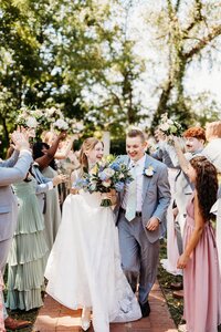 couple-walking-through-cheering-wedding-party