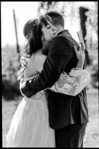 Étreinte pleine d’émotion entre deux mariés lors de leur premier regard au Vignoble de la Bauge, captée en noir et blanc — un moment authentique et intime saisi par un photographe de mariage à Montréal, célébrant la tendresse et la connexion du couple.