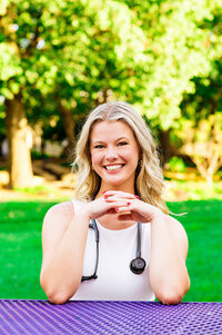 Ortho degree senior with stethoscope sitting at a table on Trevecca campus