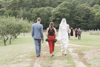 Photographer walking with bride and groom