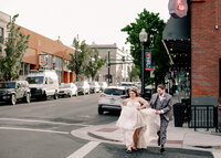 Wedding at the Hood River Hotel in Downtown Hood River with bride and groom running across the street