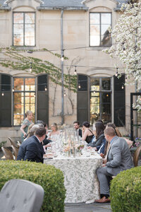 Guests enjoying an outdoor wedding reception with floral tablescape in wedding photography Detroit MI