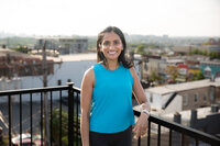 A Yoga Instructor poses for a rooftop branding headshot after leading a yoga class at a salon in Baltimore, Maryland.