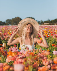 Editorial personal brand portrait of a female founder in a flower field, photographed in natural light to convey creativity and calm