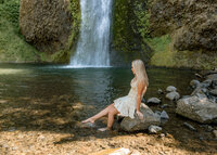 Oregon City high school senior sitting on a rock near horse tail falls for her senior portraits in the Columbia River Gorge.