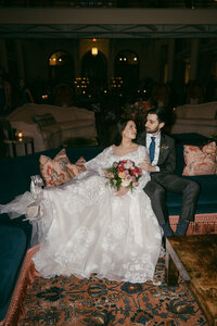bride and groom sitting on blue couch at st josephs art society