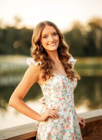 Senior portrait in downtown Magnolia Springs, Alabama — posing with hand on hip near a poind.