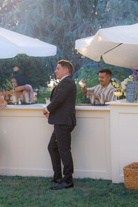 groom at sunset cocktail hour bar at rainbow oaks ranch in sanger california.