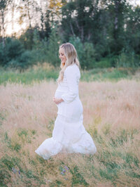 Pregnant woman walking in the grassy field