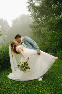 Bride and groom sharing a kiss, with the bride holding a bouquet in Cobb County.