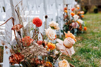 Fall florals along the aisle of an outdoor ceremony.