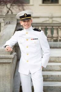 USNA senior picture in white uniform near Mahan Hall at Naval Academy by Kelly Eskelsen Photography.